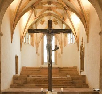 View in the choir room of Lorch Monastery church with a crucifix in the foreground